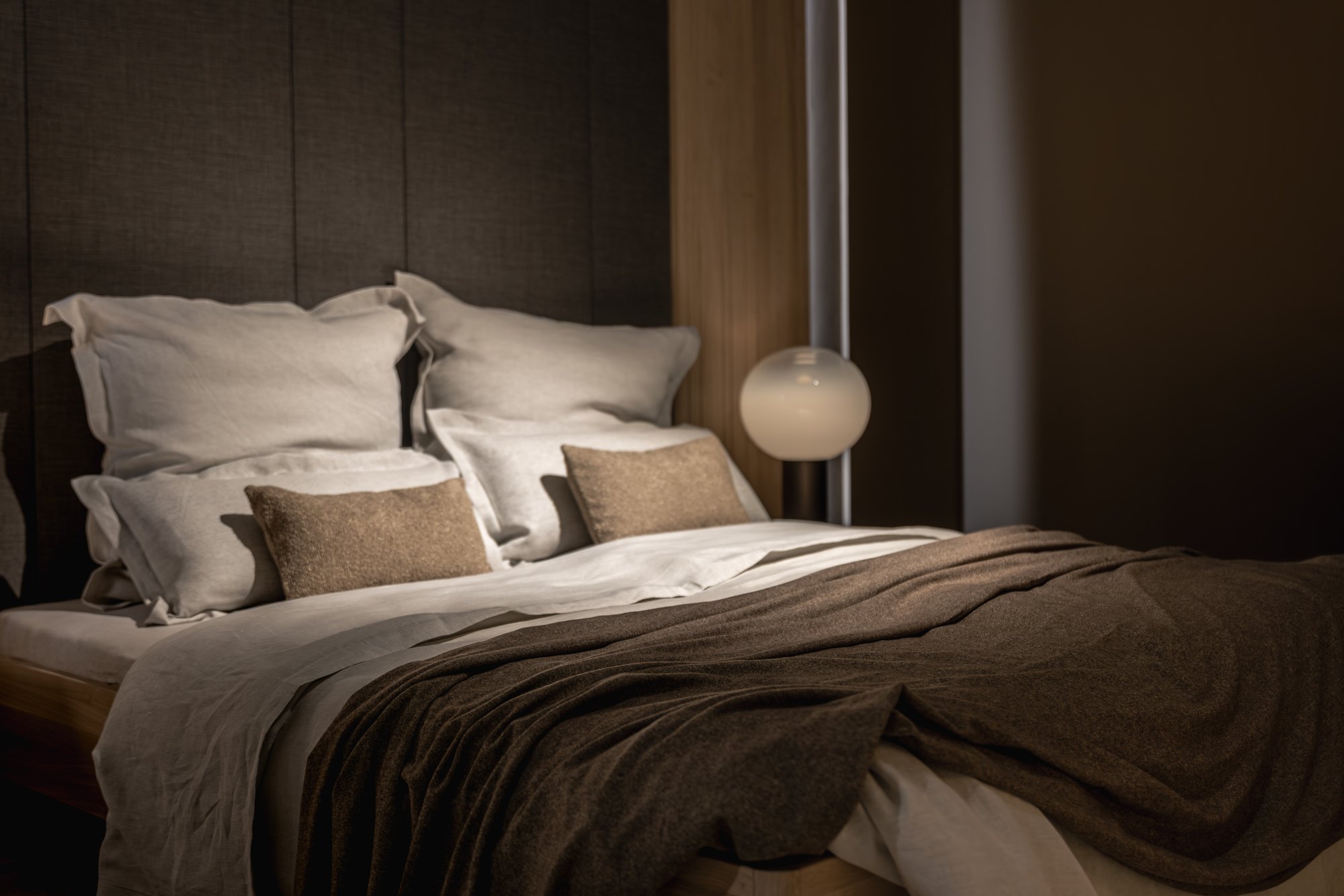 Chambre aux tons doux, lampe de chevet allumée
